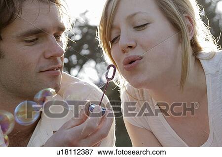 Couple blowing bubbles View Large Photo Image Stock Photo - Couple blowing bubbles. Fotosearch