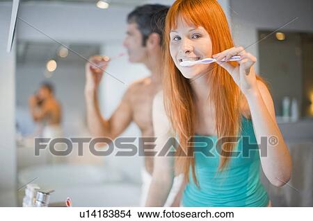 Couple brushing their teeth in bathroom View Large Photo Image Picture - Couple brushing their teeth in bathroom. Fotosearch