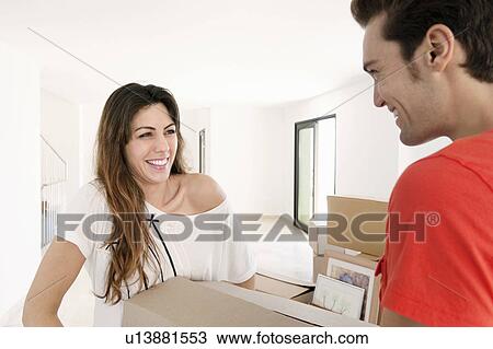 Couple carrying heavy box into new home View Large Photo Image Stock Image - Couple carrying heavy box into new home. Fotosearch