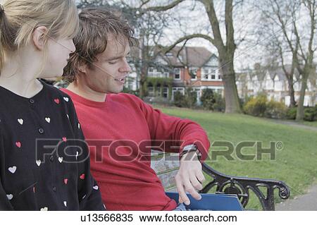 Couple checking man’s watch outdoors View Large Photo Image Stock Photography - Couple checking man’s watch outdoors. Fotosearch