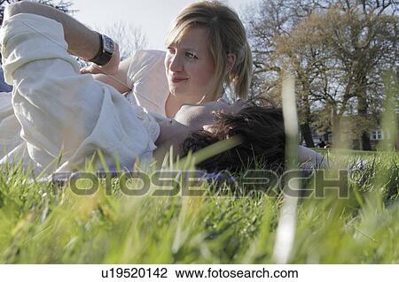 Couple checking the time in grass View Large Photo Image Stock Image - Couple checking the time in grass. Fotosearch