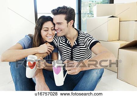 Couple drinking coffee in new home View Large Photo Image Stock Photo - Couple drinking coffee in new home. Fotosearch