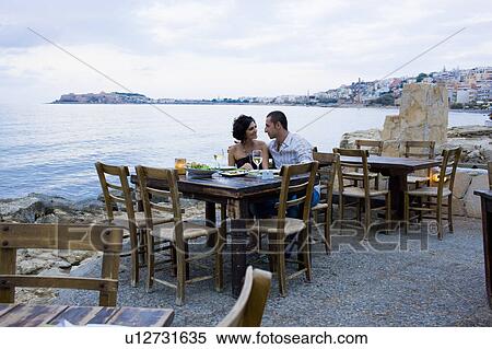Stock Photography - Couple eating at waterfront cafe. Fotosearch