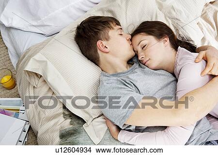Couple embracing, laying in bed View Large Photo Image Picture - Couple embracing, laying in bed. Fotosearch