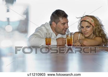 couple having a drink leaning on bar View Large Photo Image Stock Image - couple having a drink leaning on bar. Fotosearch