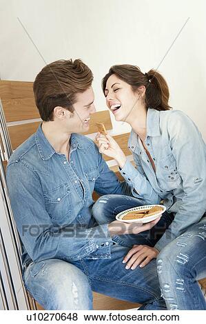 Stock Photo - Couple having a snack on stairs. Fotosearch