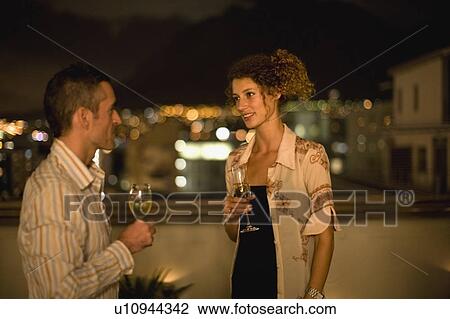 Couple having wine on terrace at night View Large Photo Image Stock Image - Couple having wine on terrace at night. Fotosearch