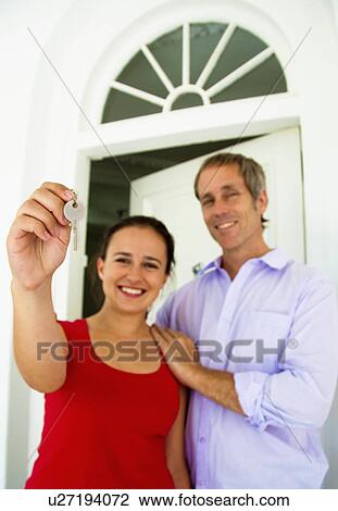 Couple hold up house key View Large Photo Image Stock Image - Couple hold up house key. Fotosearch