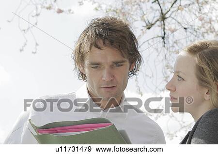 Stock Photo - Couple holding folder outdoors. Fotosearch