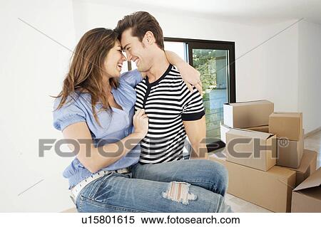 Stock Photography - Couple hugging in new home. Fotosearch