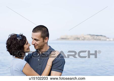 Stock Image - Couple hugging on waterfront. Fotosearch