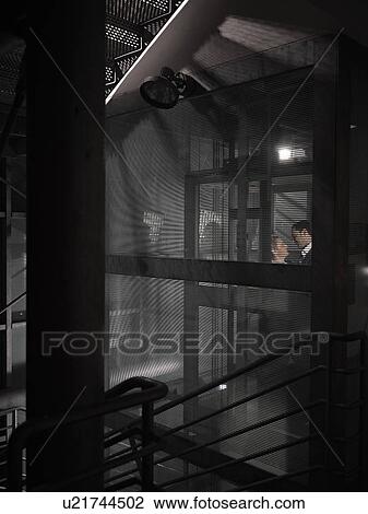 Stock Image - Couple kissing late in a lift. Fotosearch