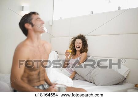 Couple laughing in bed View Large Photo Image Picture - Couple laughing in bed. Fotosearch