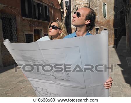 Stock Image - Couple looking at blue prints. Fotosearch