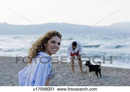 couple on beach playing with dog View Large Photo Image Stock Image - couple on beach playing with dog. Fotosearch