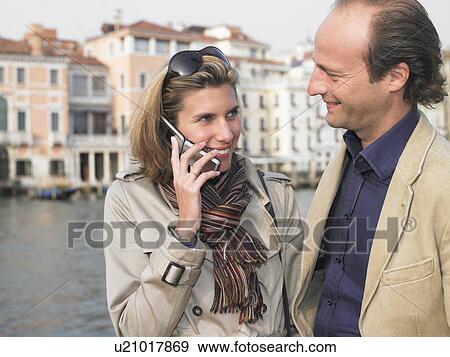 Couple on the phone in the street View Large Photo Image Stock Photo - Couple on the phone in the street. Fotosearch