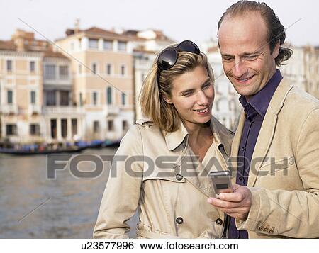 Couple on the phone in the street View Large Photo Image Stock Photograph - Couple on the phone in the street. Fotosearch