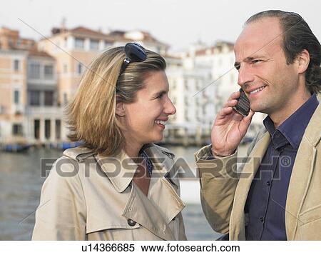 Couple on the phone in the street View Large Photo Image Stock Photography - Couple on the phone in the street. Fotosearch