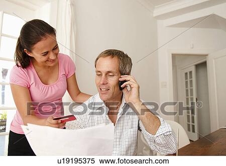Stock Photography - Couple pay bill with credit card. Fotosearch