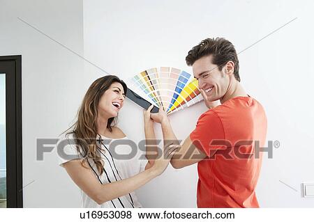 Stock Photo - Couple picking out paint in new home. Fotosearch