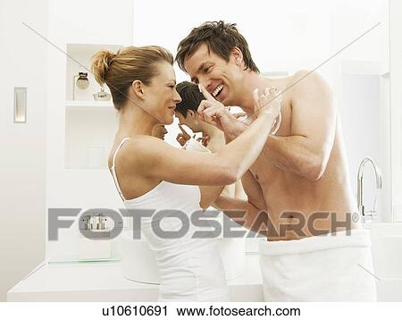 Stock Image - Couple playing in bathroom. Fotosearch