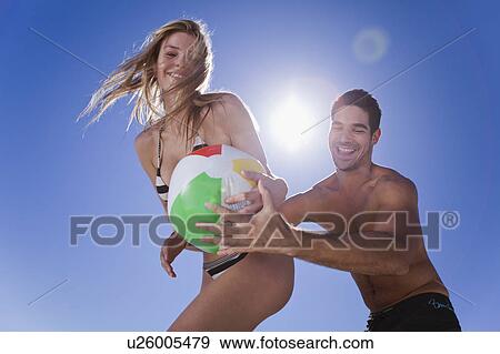 Couple playing with beach ball View Large Photo Image Stock Photo - Couple playing with beach ball. Fotosearch