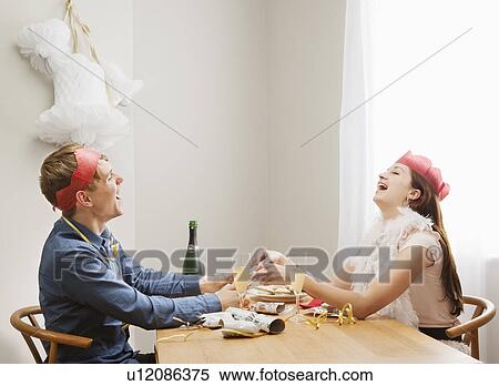 Stock Photography - Couple pulling christmas crackers. Fotosearch