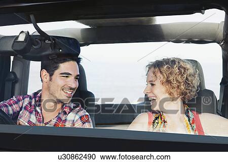 Stock Image - Couple riding in jeep together. Fotosearch