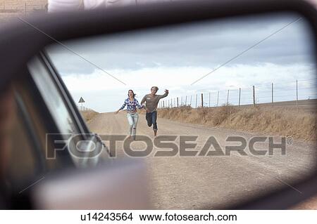 Couple running behind car View Large Photo Image Picture - Couple running behind car. Fotosearch
