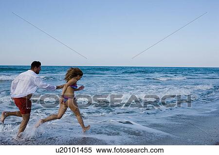 Stock Photography - couple running on the beach. Fotosearch