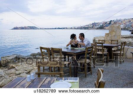 Stock Photo - Couple sitting at waterfront cafe. Fotosearch