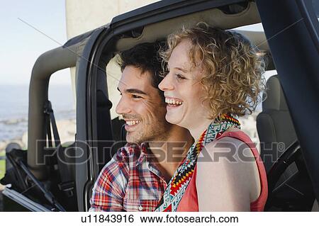 Stock Photograph - Couple smiling in jeep. Fotosearch