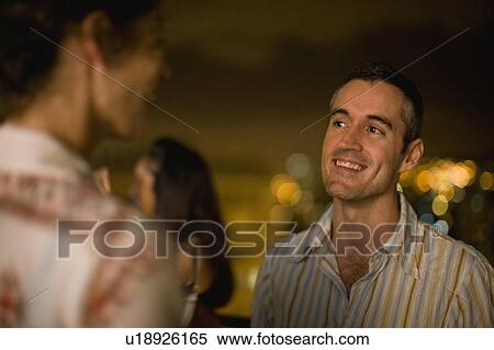 Couple talking outdoors at night View Large Photo Image Stock Photography - Couple talking outdoors at night. Fotosearch