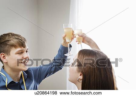 Stock Photo - Couple toasting with champagne glasses. Fotosearch