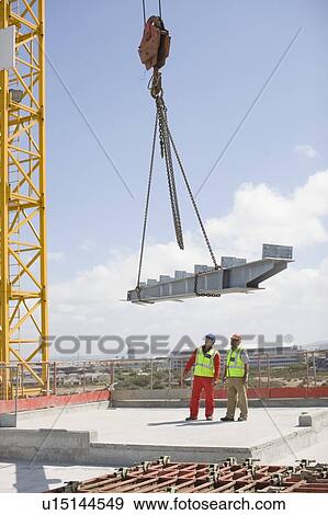 Stock Photo - Crane and workers on construction site. Fotosearch