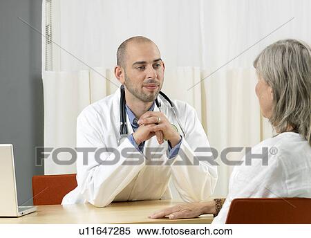 Doctor consulting lady View Large Photo Image Stock Photography - Doctor consulting lady. Fotosearch