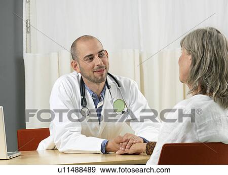 Stock Photo - Doctor consulting mature woman. Fotosearch