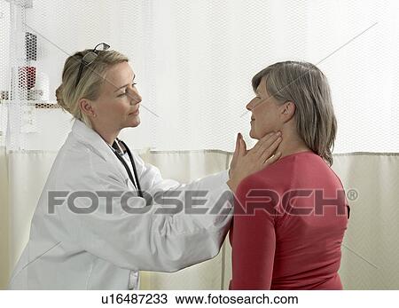 Stock Image - Doctor examining mature woman. Fotosearch