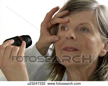 Stock Image - Doctor examining mature woman. Fotosearch