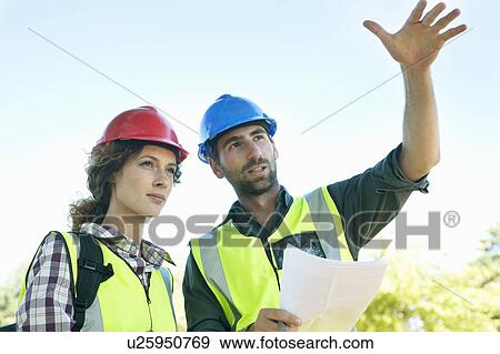 Stock Photo - Engineer and Architect discussing plans. Fotosearch