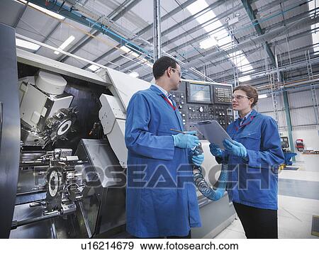 Stock Photo - Engineers with machinery in factory. Fotosearch