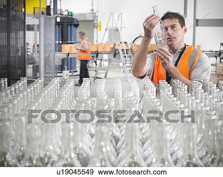 Factory worker examining bottles View Large Photo Image Stock Photo - Factory worker examining bottles. Fotosearch