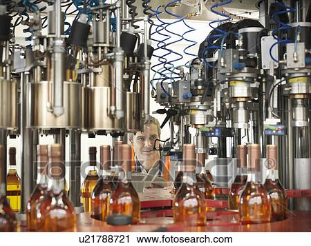 Factory worker in bottling plant View Large Photo Image Stock Image - Factory worker in bottling plant. Fotosearch