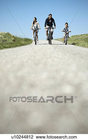 Family cycling down country road View Large Photo Image Stock Image - Family cycling down country road. Fotosearch