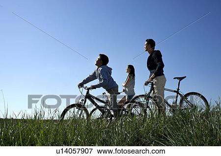 Stock Photo - Family with bicycles resting in the sun. Fotosearch