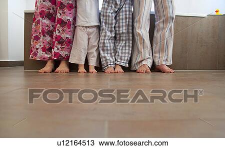 Stock Image - Family’s feet in bathroom. Fotosearch