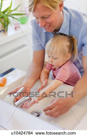 Picture - Father and daughter washing hands. Fotosearch