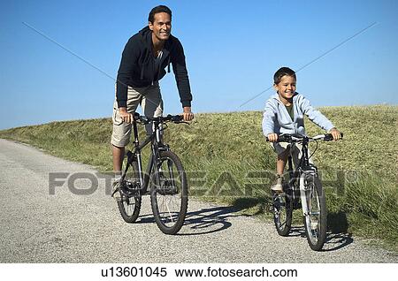 Stock Photography - Father and son cycling. Fotosearch