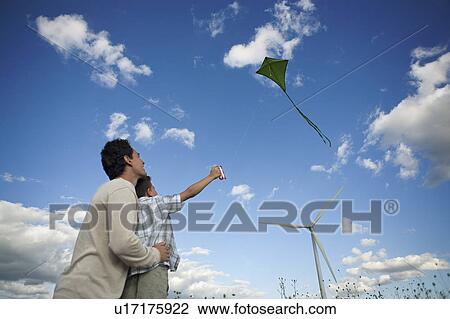 Stock Image - Father and son flying a kite. Fotosearch