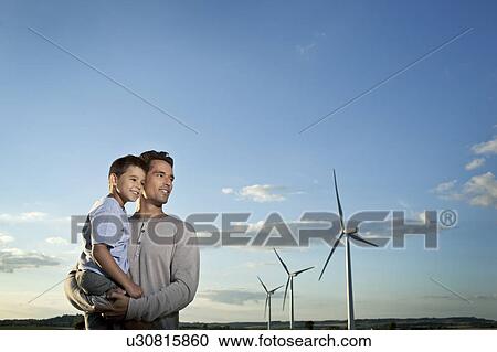 Stock Image - Father and son on a windfarm. Fotosearch